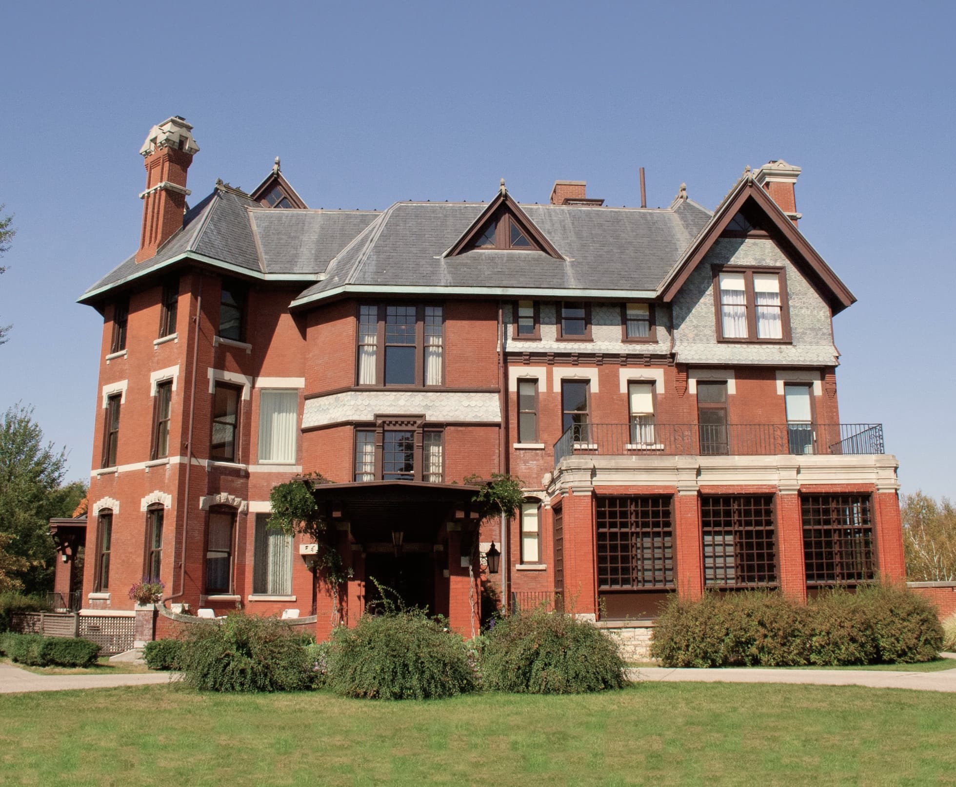 A red-brick Victorian mansion in Cedar Rapids, Iowa, behind a green lawn
